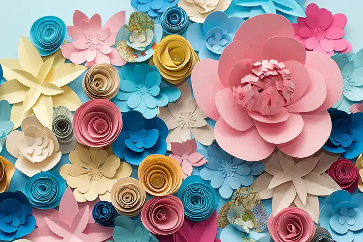 Colorful paper flowers backdrop with various shades of pink, blue, yellow, and cream, ideal for photography and events