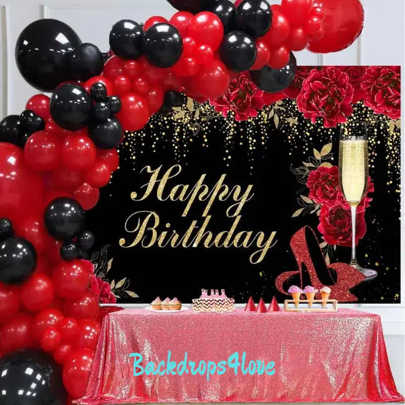 Red and gold-themed birthday party backdrop featuring roses, glitter details, and a champagne glass.