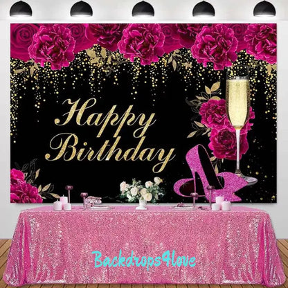 Black and gold Happy Birthday backdrop with pink roses, champagne glass, and glitter accents.