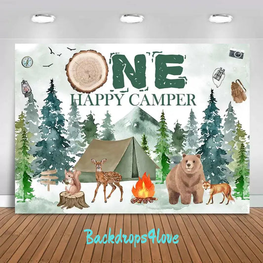 Camping-themed birthday backdrop with forest, tent, and woodland animals including a bear, fox, and deer.