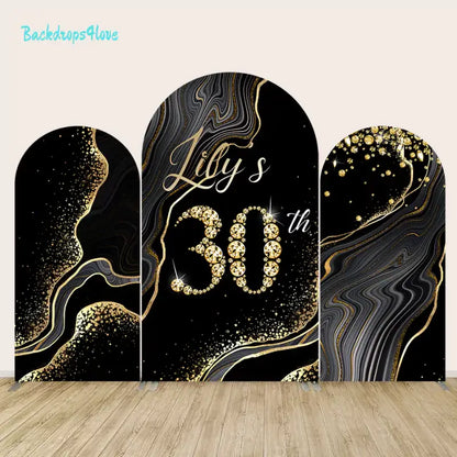 Arch backdrop set with luxurious black and gold designs and glittering elements for a 30th birthday party