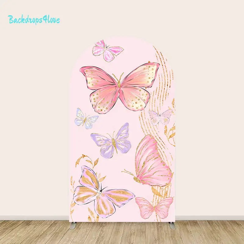 A delicate and elegant backdrop featuring pink and purple butterflies adorned with golden accents and glitter details. The soft pastel pink background includes flowing gold streaks and botanical elements, creating a whimsical and sophisticated design perfect for events like birthdays or baby showers.