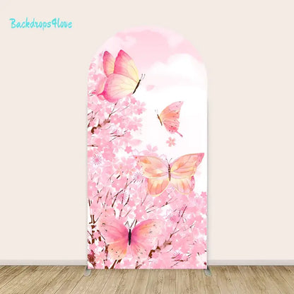 A dreamy and elegant backdrop featuring pink and orange butterflies fluttering among cherry blossoms. The background includes soft pastel pink skies with fluffy clouds, creating a serene and whimsical atmosphere perfect for spring-themed or nature-inspired events.