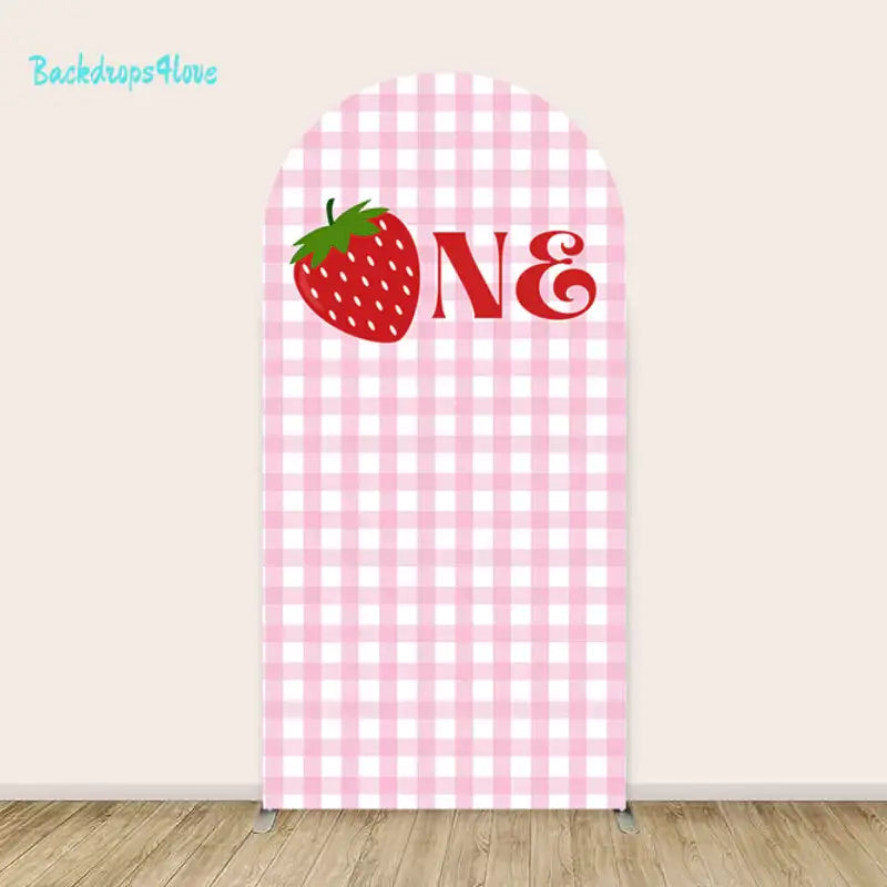 Left arch with pink gingham pattern and large strawberry with the word 'ONE