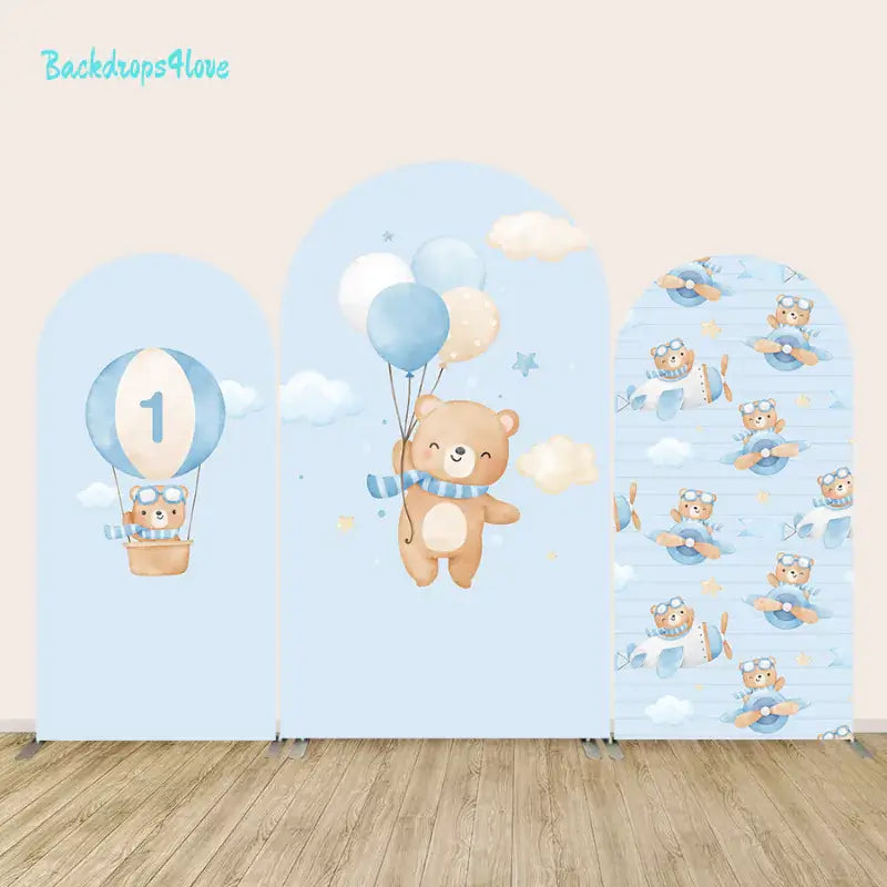 Three-piece arched backdrop set featuring a teddy bear in a hot air balloon, a bear with balloons in a starry sky, and teddy bear pilots flying planes, in a soft blue theme.