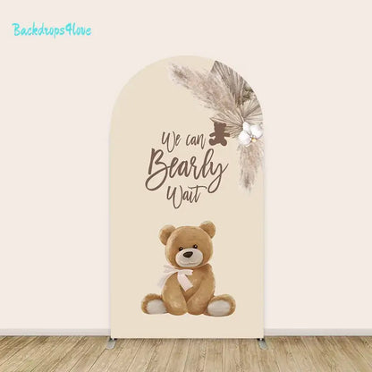 Center arch backdrop with 'We Can Bearly Wait' text, cute teddy bear, and floral accents for baby shower