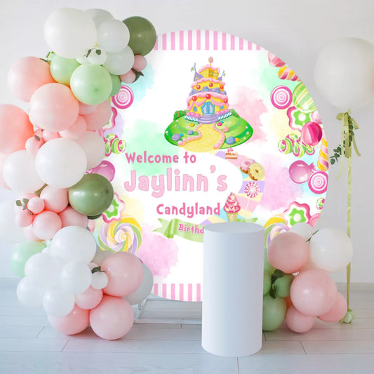 Personalized round Candyland birthday backdrop featuring a colorful candy castle and sweets, surrounded by pastel balloons and a white pedestal for party decorations.