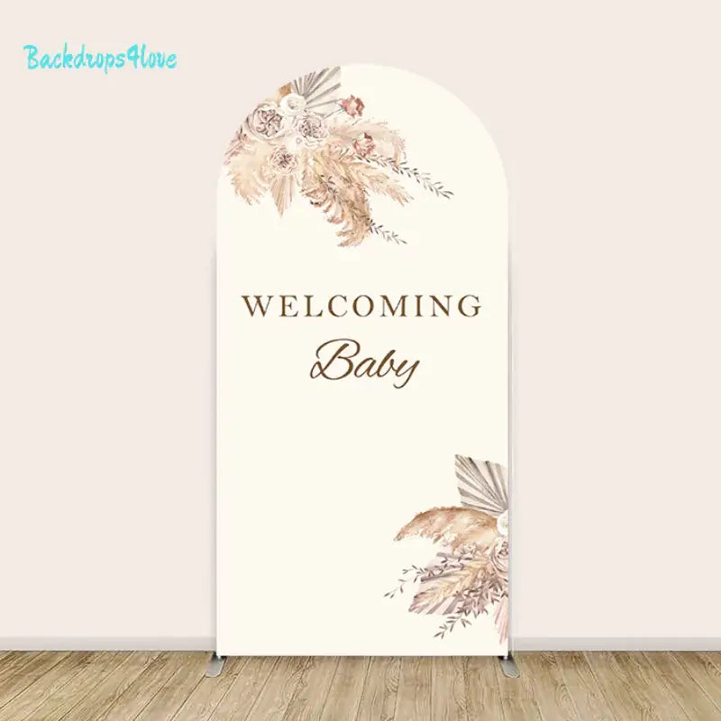 Floral arch backdrop with 'Welcoming Baby' text for baby showers